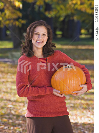 Hispanic woman holding pumpkin 11633895