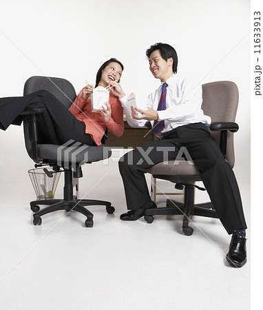 Studio shot of Asian businesspeople eating take out 11633913
