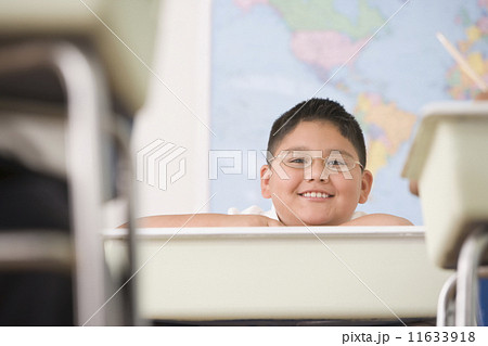 Hispanic boy sitting at school desk 11633918
