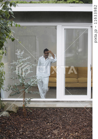 Middle Eastern man looking out glass wall 11633982