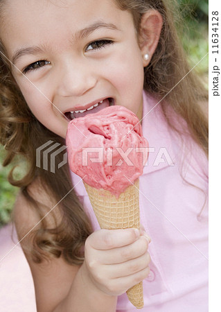 Hispanic girl eating ice cream cone 11634128