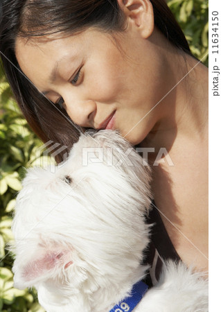 Asian woman kissing dog Asian woman kissing dog 11634150
