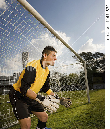 Hispanic male soccer player blocking goal 11634376