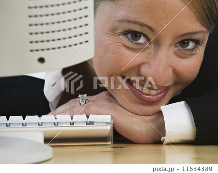 Portrait of businesswoman leaning on desk Portrait of businesswoman leaning on desk 11634389
