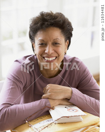 Middle-aged woman smiling for the camera at her desk Middle-aged woman smiling for the camera at her desk 11634481