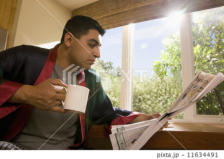 Hispanic man reading newspaper Hispanic man reading newspaper 11634491