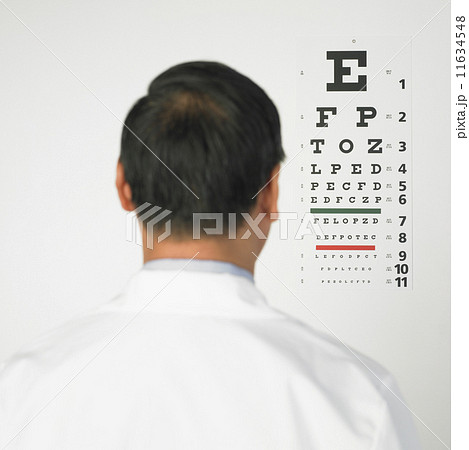 Rear view of Asian man looking at eye chart Rear view of Asian man looking at eye chart 11634548