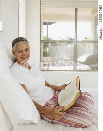 Asian woman reading on bed Asian woman reading on bed 11634569