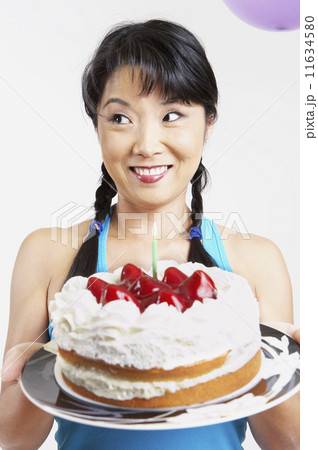 Asian woman holding cake with candle 11634580