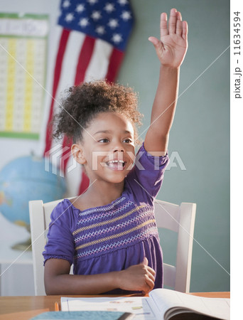 Mixed race girl answering question in classroom Mixed race girl answering question in classroom 11634594