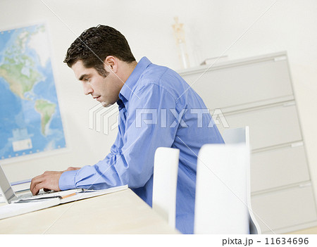 Hispanic man typing on laptop Hispanic man typing on laptop 11634696