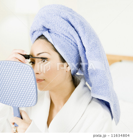 Hispanic woman applying mascara Hispanic woman applying mascara 11634804