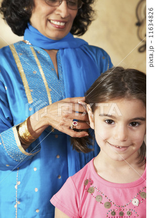 Indian grandmother fixing granddaughter's hair Indian grandmother fixing granddaughter's hair 11634826