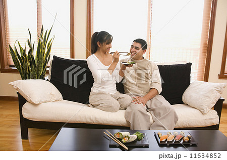 Hispanic woman feeding sushi to husband 11634852