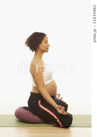 Pregnant Mixed Race woman meditating 11634862