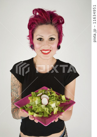 Studio shot of woman holding plate of salad Studio shot of woman holding plate of salad 11634951