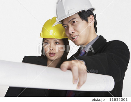Studio shot of Asian businesspeople wearing hard hats Studio shot of Asian businesspeople wearing hard hats 11635001