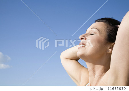 Hispanic woman with hands behind head 11635030