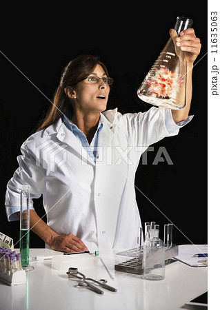 Maltese female scientist looking at energy in beaker 11635063