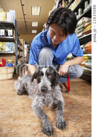 Asian man petting dog in pet store 11635086