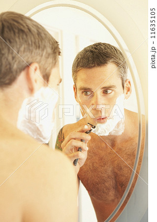 Man shaving in mirror 11635105