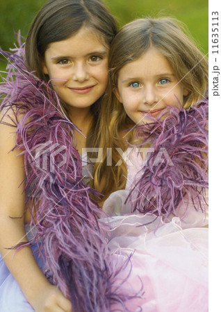 Two young girls wearing feather boa and smiling 11635113