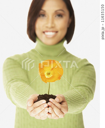 Asian woman holding flower in dirt 11635150