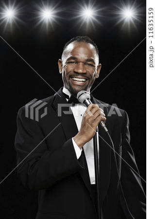 African American man in tuxedo holding microphone 11635159