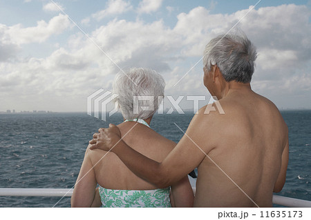 Senior Asian couple looking out over water Senior Asian couple looking out over water 11635173