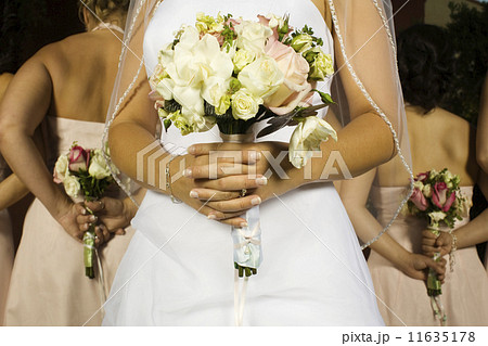 Close up of Hispanic bride holding bouquet 11635178