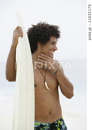 South American man holding surfboard 11635179