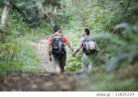 Rear view of couple hiking on trail 11635224
