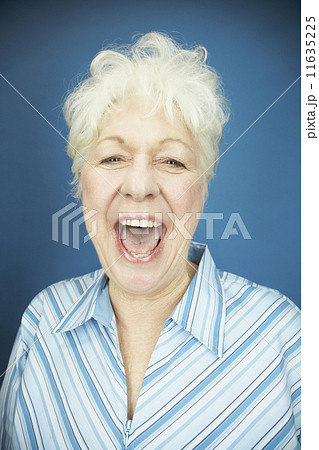 Studio shot of senior woman laughing Studio shot of senior woman laughing 11635225