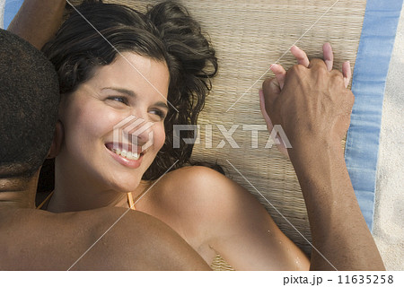 Hispanic couple laying on beach mat 11635258