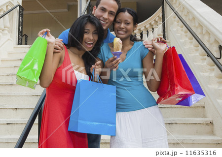 Hispanic friends holding shopping bags Hispanic friends holding shopping bags 11635316