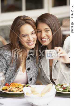 Two women taking a self-portrait at lunch  11635370