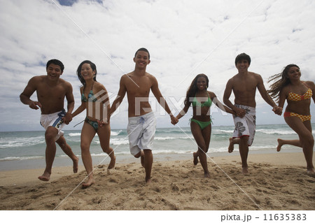Multi-ethnic friends running on beach Multi-ethnic friends running on beach 11635383