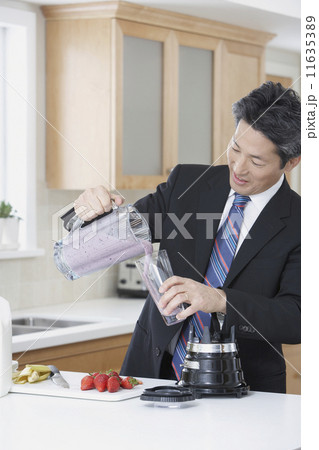 Asian businessman making fruit smoothie Asian businessman making fruit smoothie 11635389