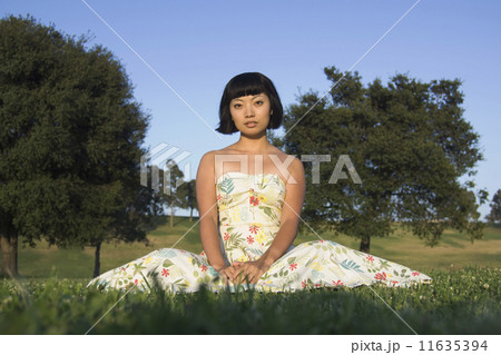 Asian woman sitting in grass 11635394