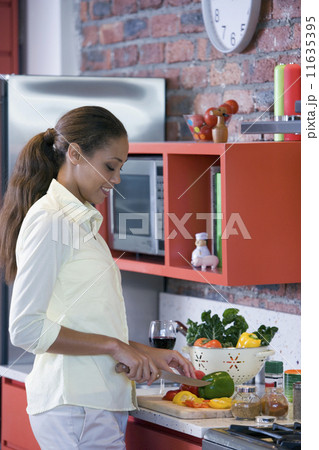 African American woman chopping vegetables 11635395