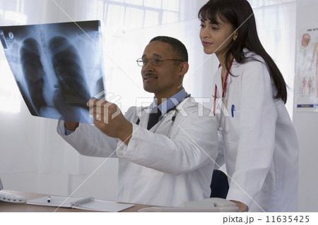 Multi-ethnic doctors looking at x-ray 11635425