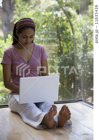 Young woman typing on laptop Young woman typing on laptop 11635436