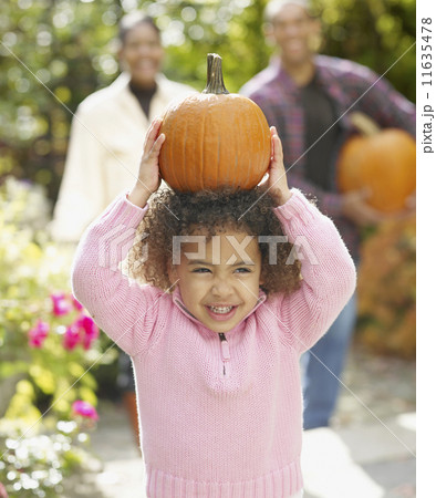 African girl holding pumpkin on head 11635478