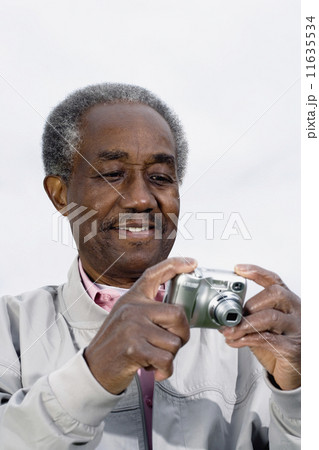 Senior African man looking at digital camera 11635534