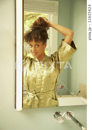 African American woman putting up hair 11635624