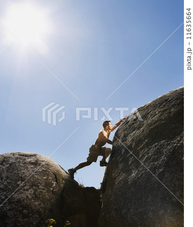 Pacific Islander man climbing rock formations 11635664