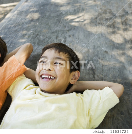 Asian boy laying with arms behind head Asian boy laying with arms behind head 11635722