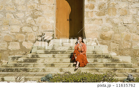 Hispanic woman sitting on stone steps 11635762
