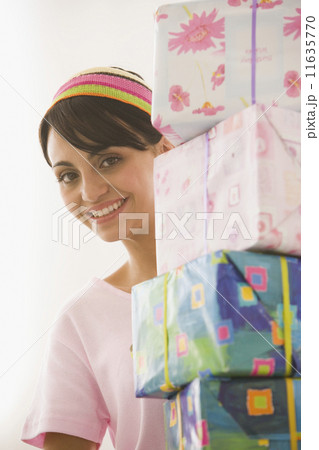 Young woman carrying stack of gifts Young woman carrying stack of gifts 11635770