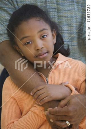 African father hugging young daughter outdoors 11635789